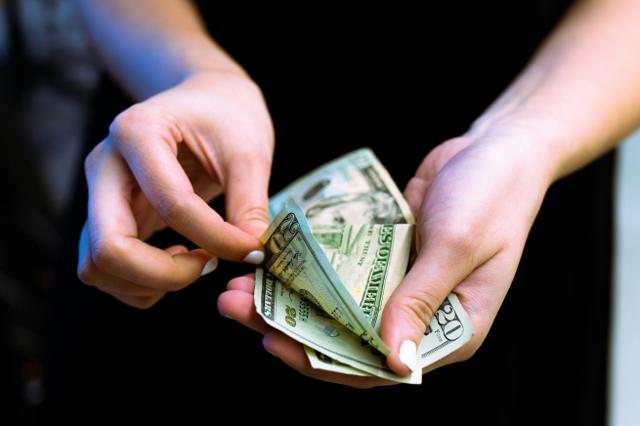 Hand holding a fan of hundred-dollar bills
